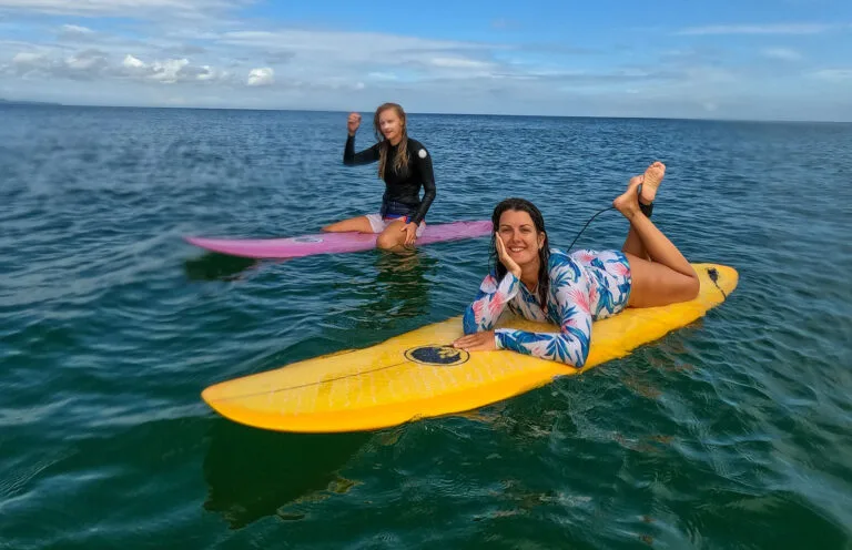 Surf Bali Surf School, sitting on the top of surf board at the beach